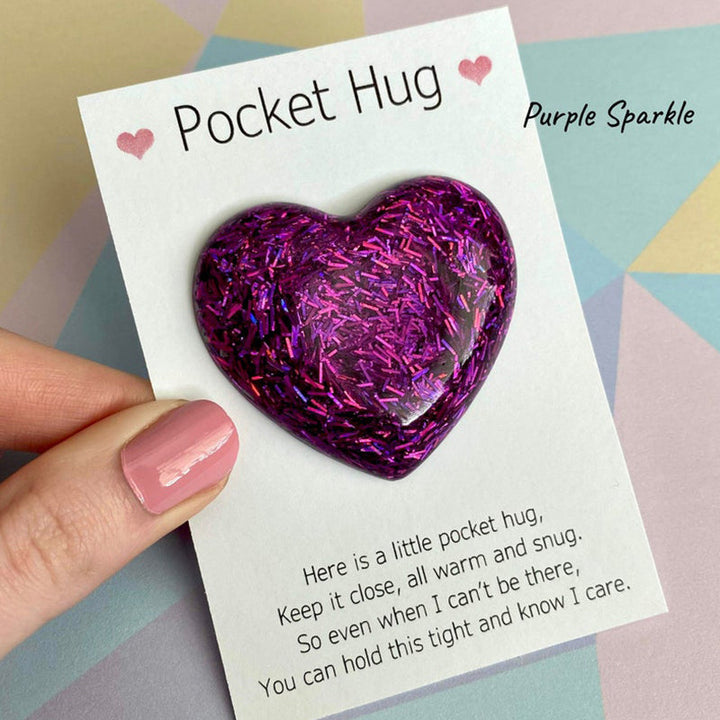 Pocket Hug heart charm next to a comforting tea cup, a thoughtful small gift