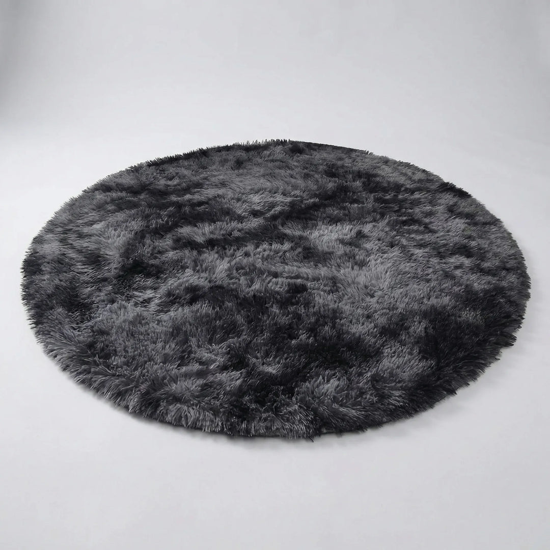 Soft plush round tie-dye rug, perfect for cozy bedroom decor or a comfortable living room accent.