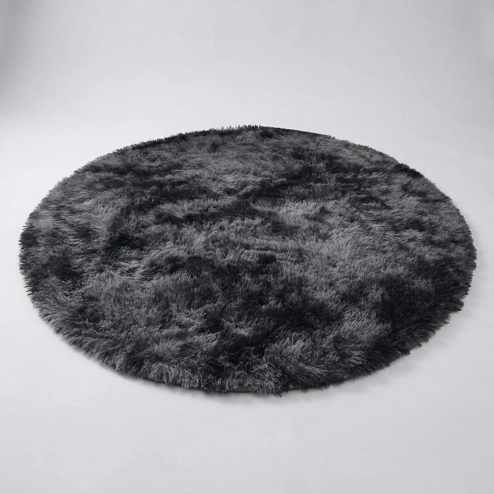 Soft plush round tie-dye rug, perfect for cozy bedroom decor or a comfortable living room accent.
