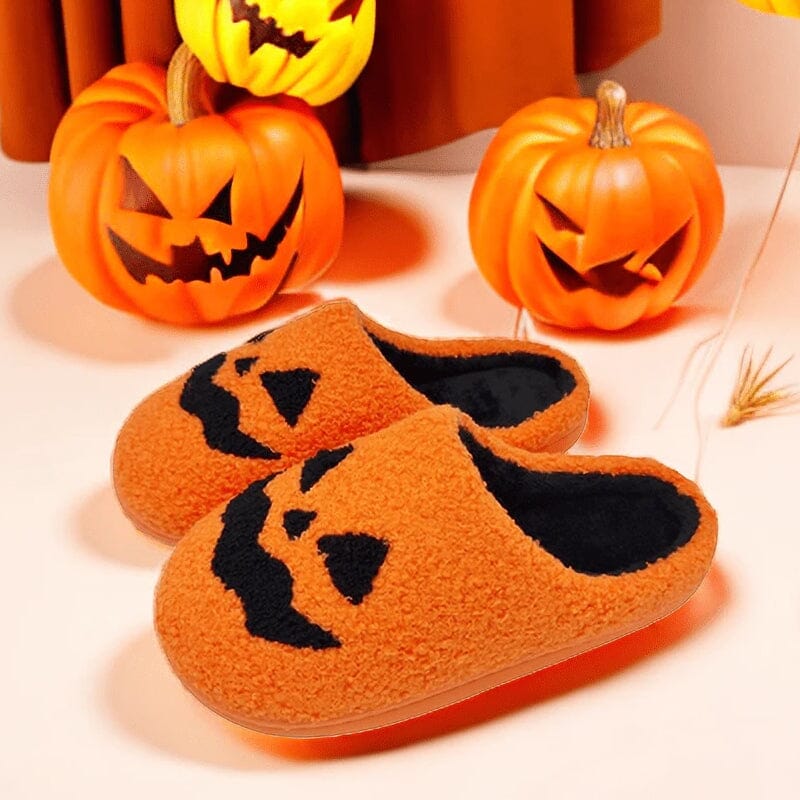 Close-up of a women's plush slipper, showcasing the embroidered pumpkin face detail.
