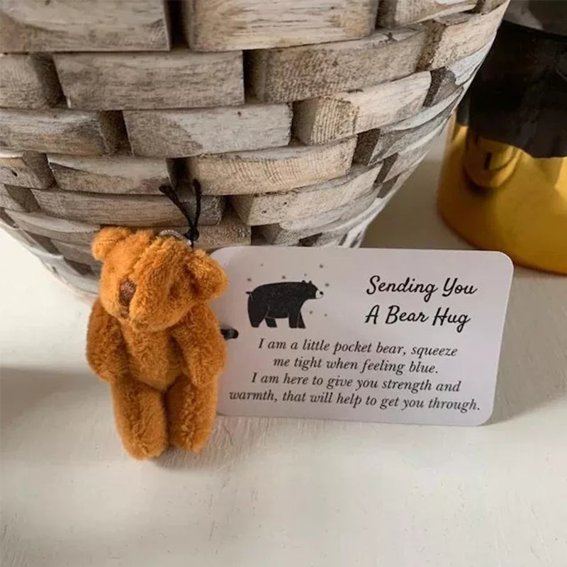 Close-up of a pocket bear plush toy keychain, showcasing its soft texture and friendly embroidered face.