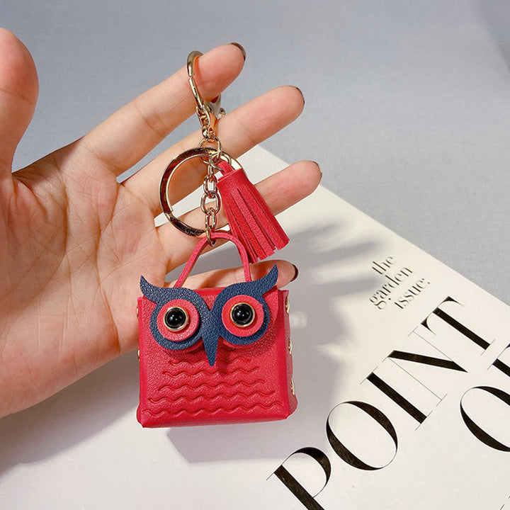 Black mini handbag keychain open, revealing small interior storage space for rings or pills