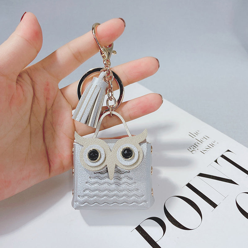 Collection of mini handbag keychains in various colors hung on a display, emphasizing their appeal