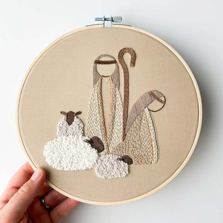 Components of the craft kit laid out: fabric, thread organiser, hoop for Nativity Scene