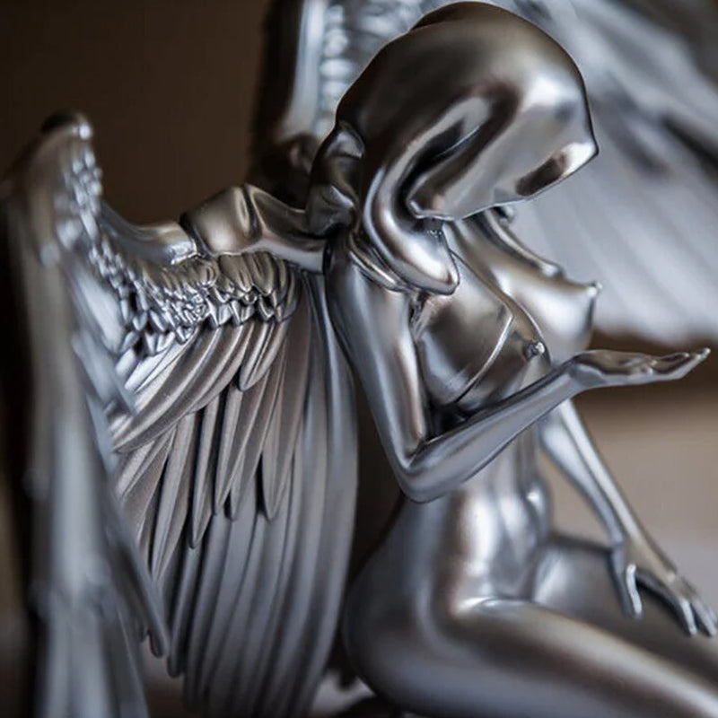 Close-up of intricate angel wings kneeling figurine, a beautiful resin statue gift