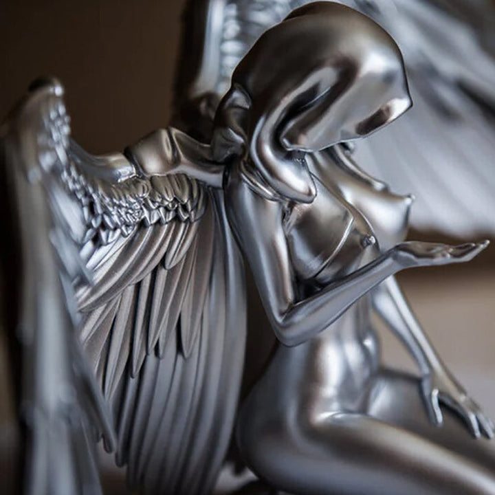Close-up of intricate angel wings kneeling figurine, a beautiful resin statue gift