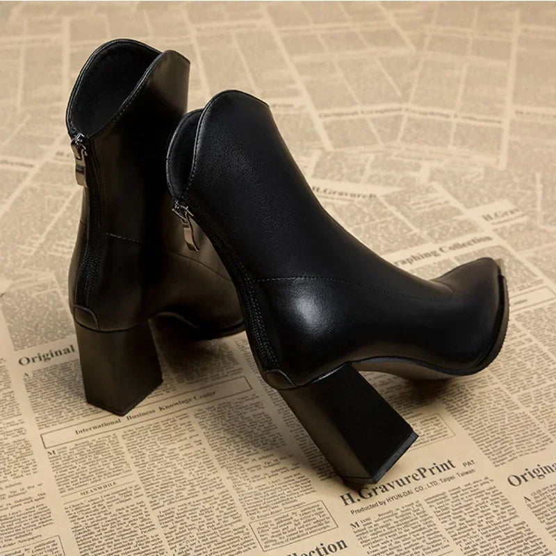 Modern women's black ankle boots, featuring a distinct pointed toe and a fashionable block heel.