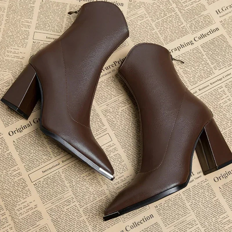 Full view of women's black ankle boots, showcasing the contemporary pointed toe and block heel.
