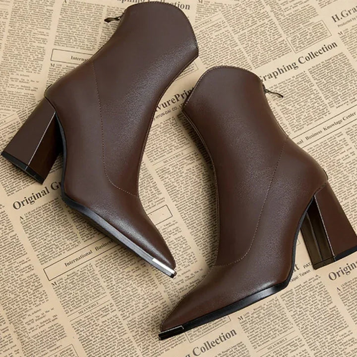 Full view of women's black ankle boots, showcasing the contemporary pointed toe and block heel.
