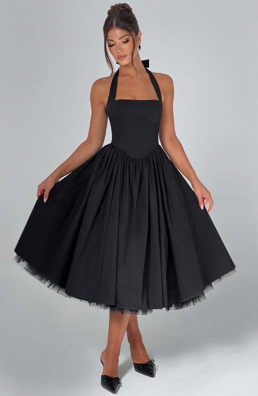Halter neck midi dress in white, folded neatly, showcasing its elegant fabric and design