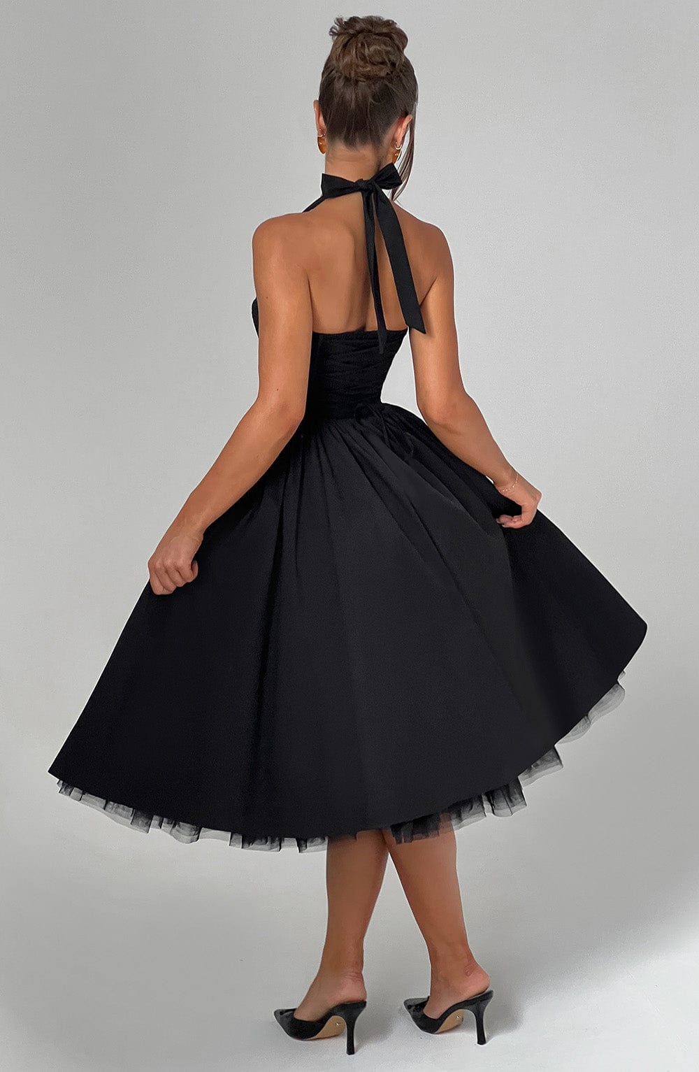 Two women showcasing the versatile black and white halter neck midi dresses for formal events