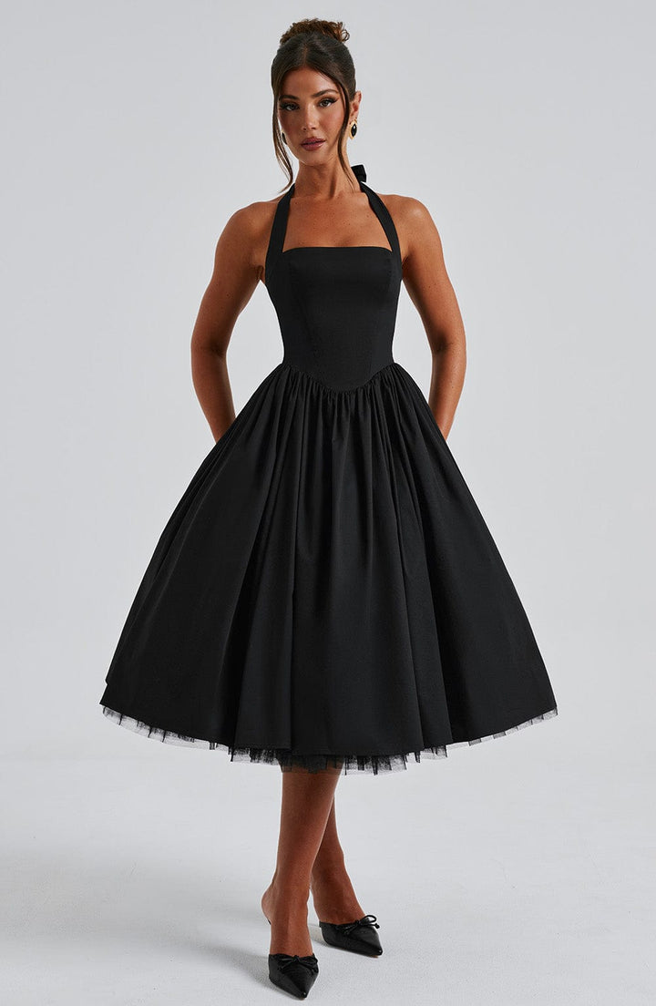 Halter neck midi dress in black, draped on a hanger, ready for a special occasion or formal event