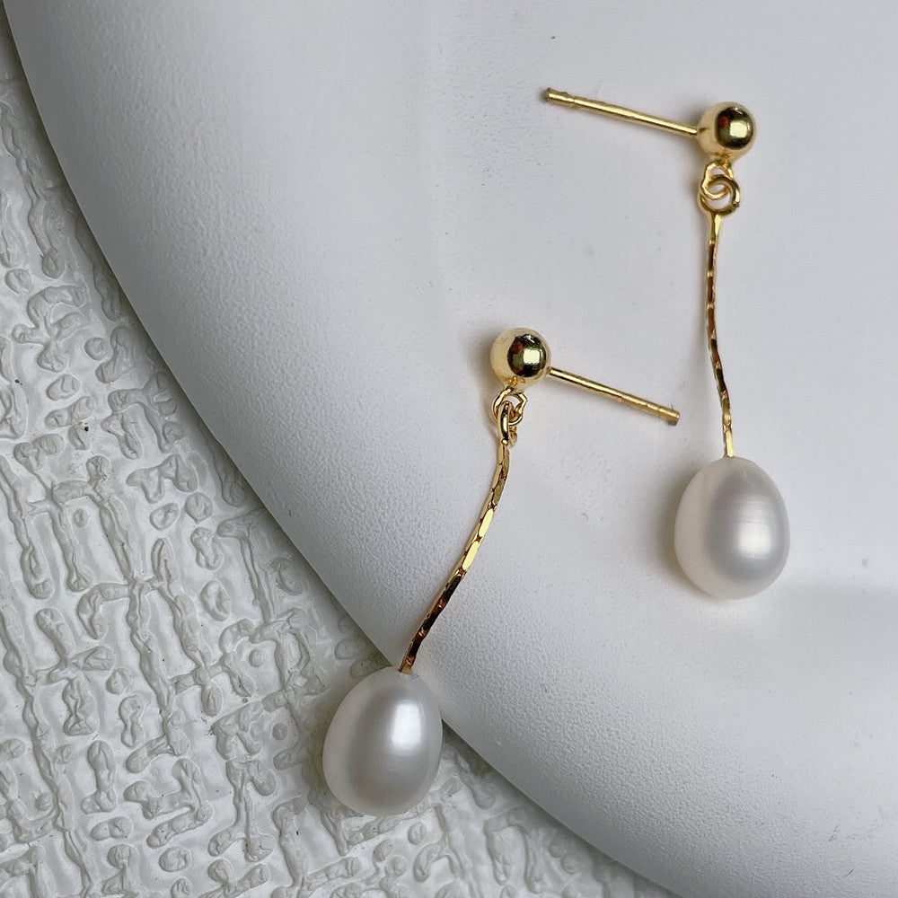 Elegant gold finish pearl stud earrings for women, timeless versatile fashion jewelry accessory.