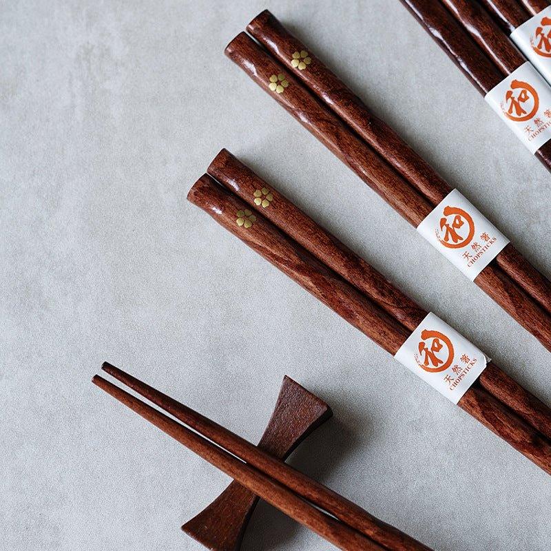Japanese style wooden chopsticks with delicate golden cherry blossom design, ideal for elegant dining and kitchenware.