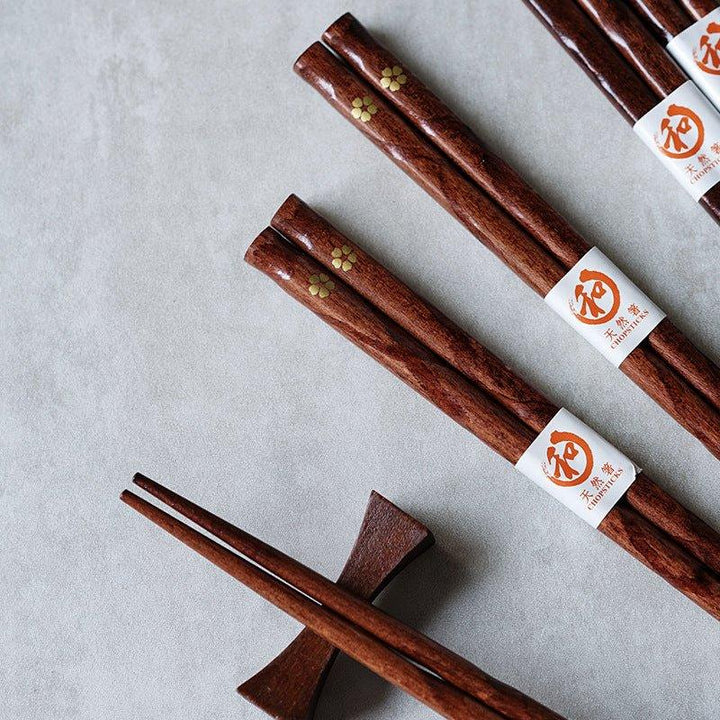 Japanese style wooden chopsticks with delicate golden cherry blossom design, ideal for elegant dining and kitchenware.