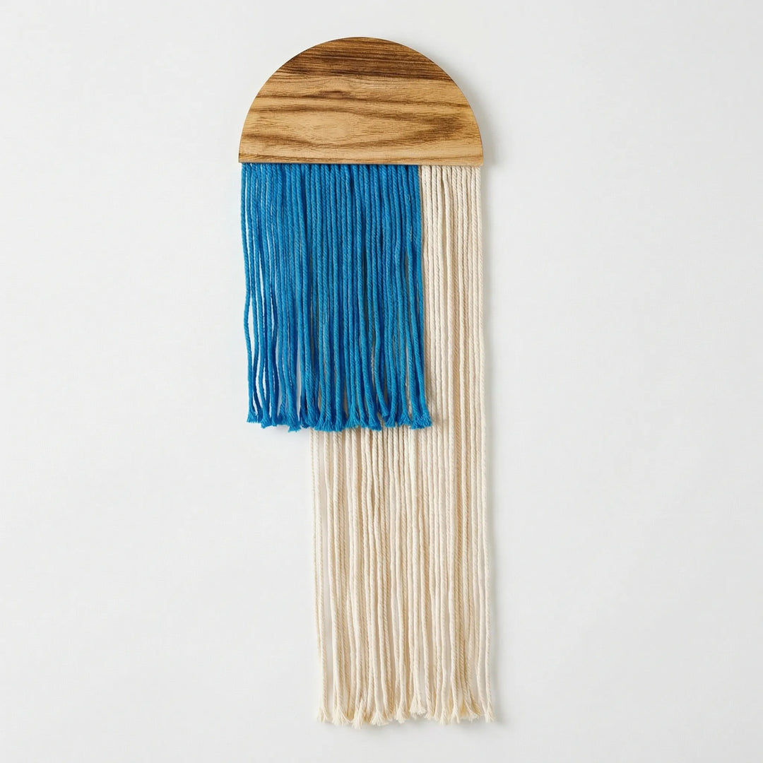 Hand-woven half circle wall art with a contemporary wave pattern and decorative fringe.