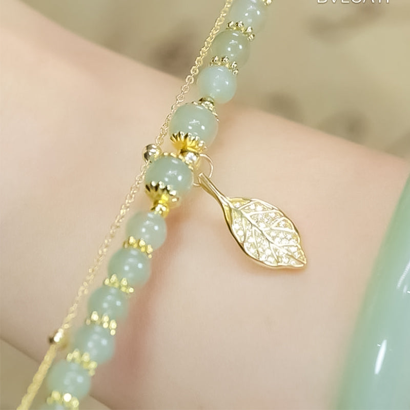 Artistic display of a Hetian jade and gold leaf bracelet, highlighting its elegant craftsmanship