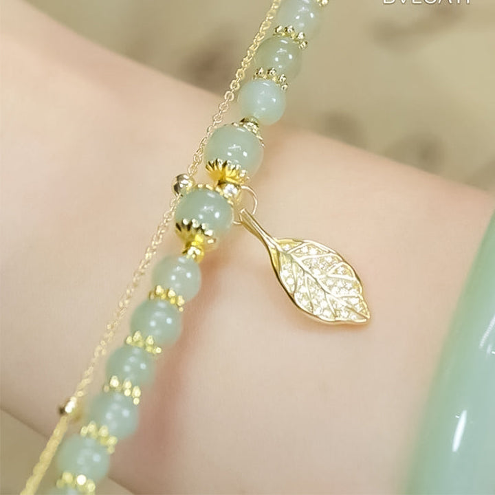 Artistic display of a Hetian jade and gold leaf bracelet, highlighting its elegant craftsmanship