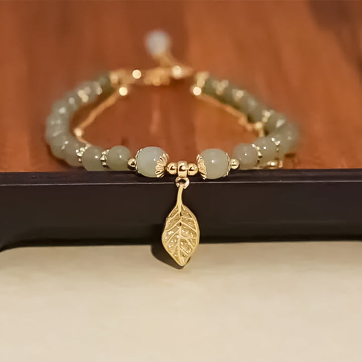 Close-up of Hetian jade bracelet, showcasing intricate gold leaf details, ideal for anniversaries