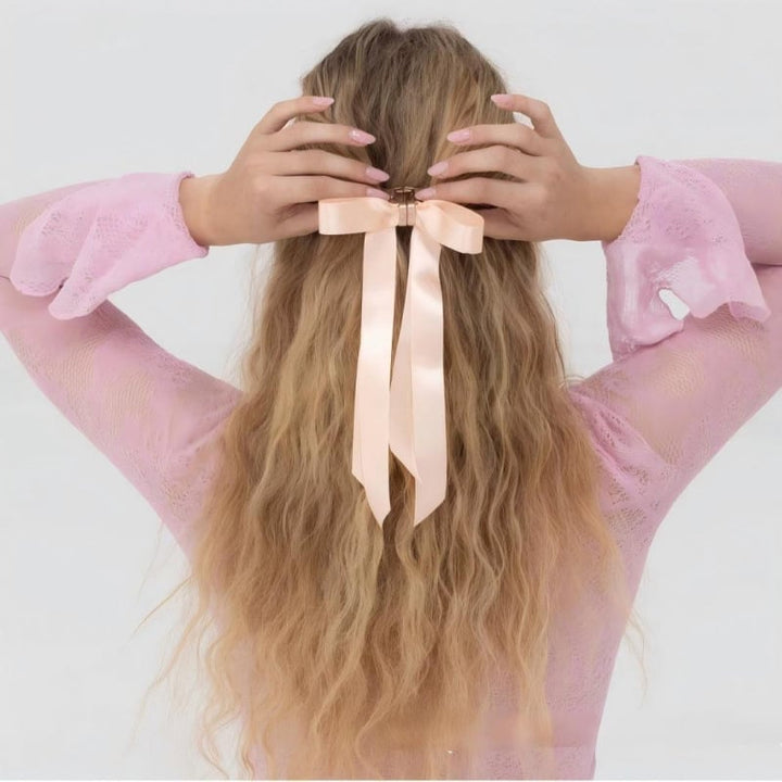 A woman's full hairstyle, enhanced with a magnetic bow hair clip for significant volume.