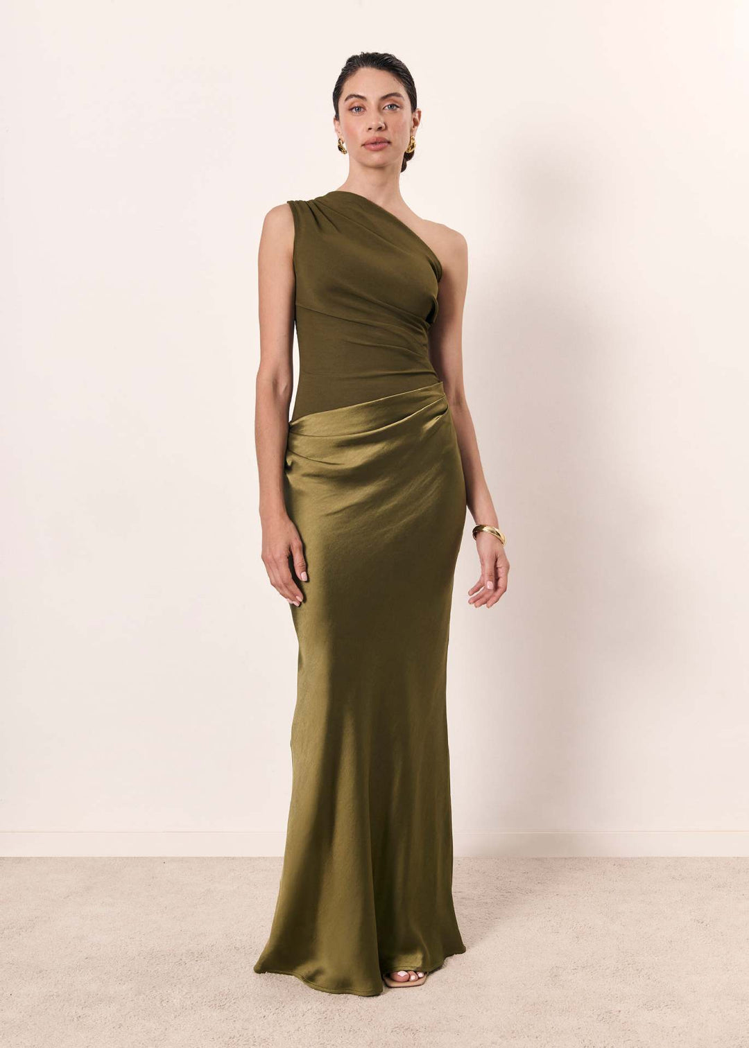 Back view of a women's elegant one-shoulder evening dress, showcasing the flowing silhouette