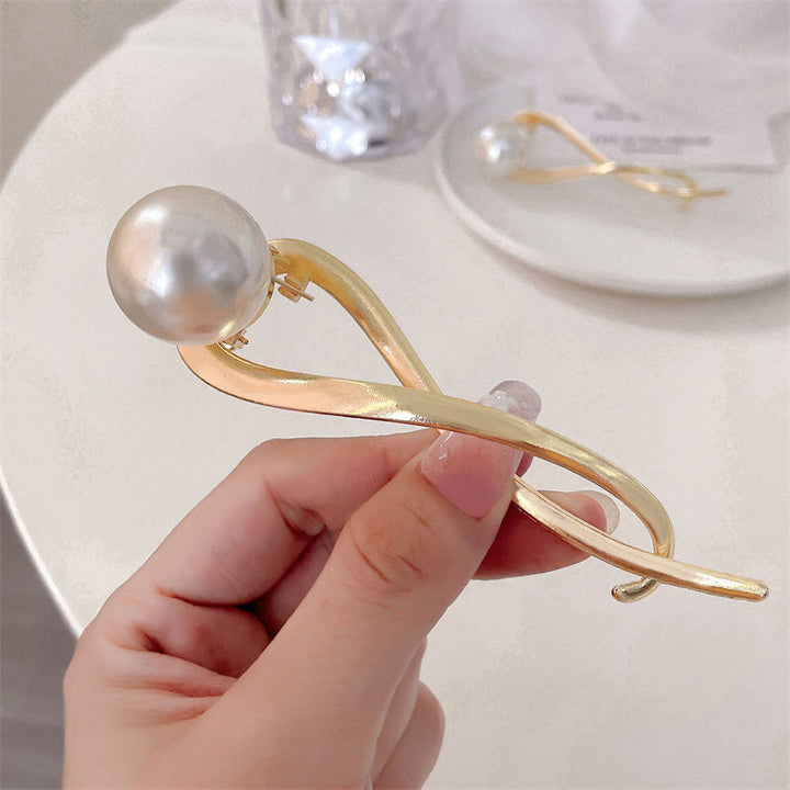 Women's alloy hair clip adorned with lustrous pearls, an elegant fashion accessory and gift for her.