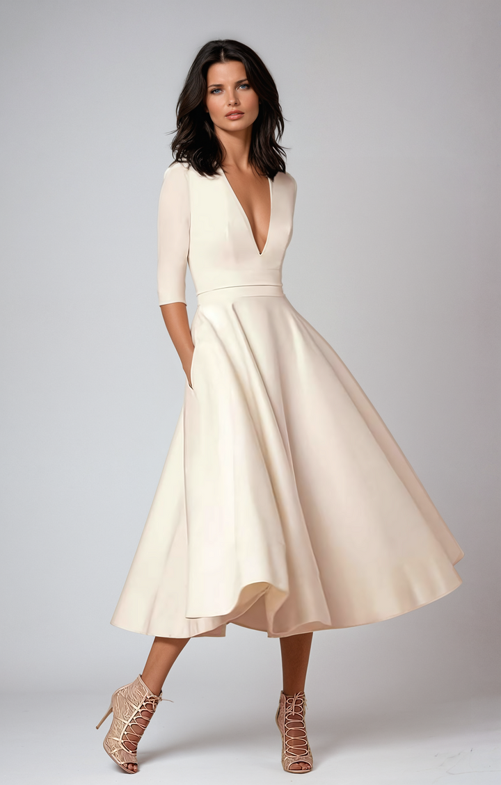 Elegant white flared midi dress, perfect for wedding guests, showcasing refined cocktail attire.