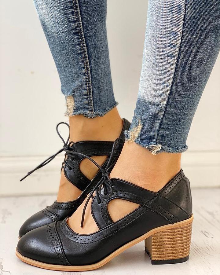 Close-up of a women's heeled lace-up T-strap shoe, highlighting the intricate lacing and T-strap design.