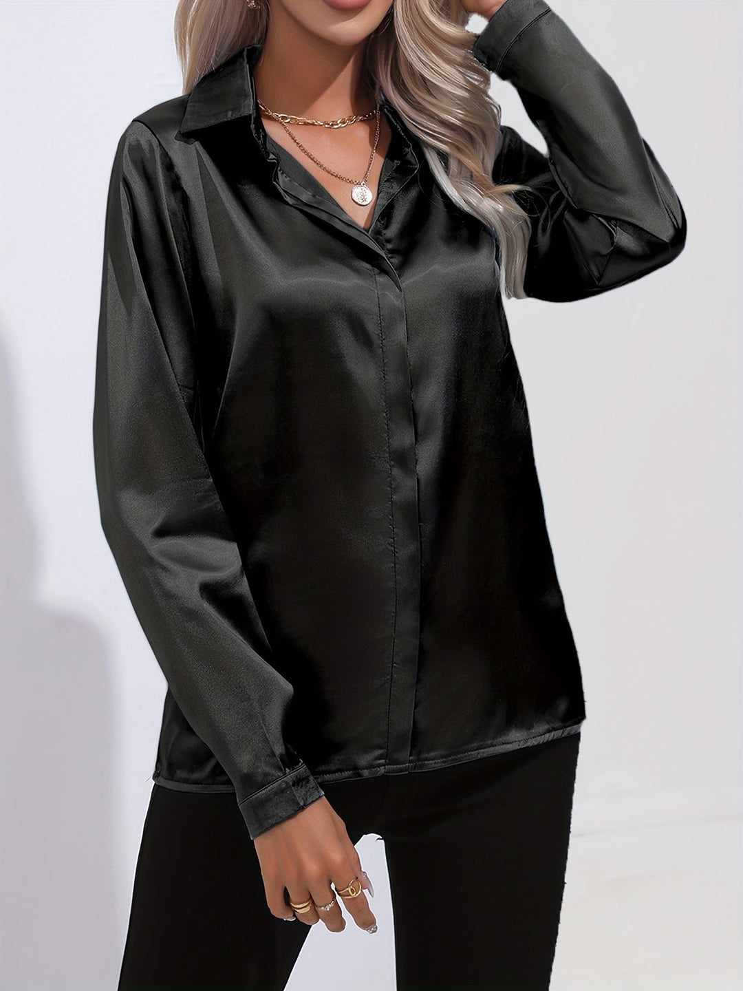 Detailed shot of the cuff and buttons on a women's satin long-sleeve button-down blouse, showcasing quality.
