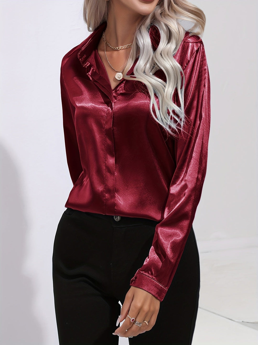 Close-up of a women's satin long-sleeve button-down blouse, highlighting the smooth fabric and sophisticated buttons.