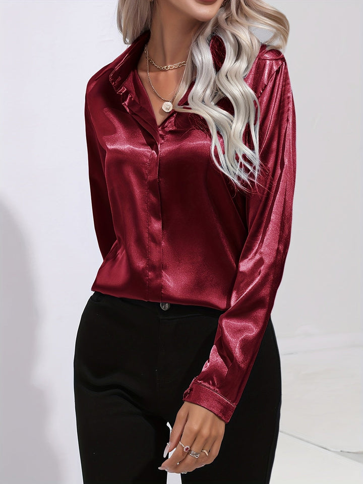 Close-up of a women's satin long-sleeve button-down blouse, highlighting the smooth fabric and sophisticated buttons.