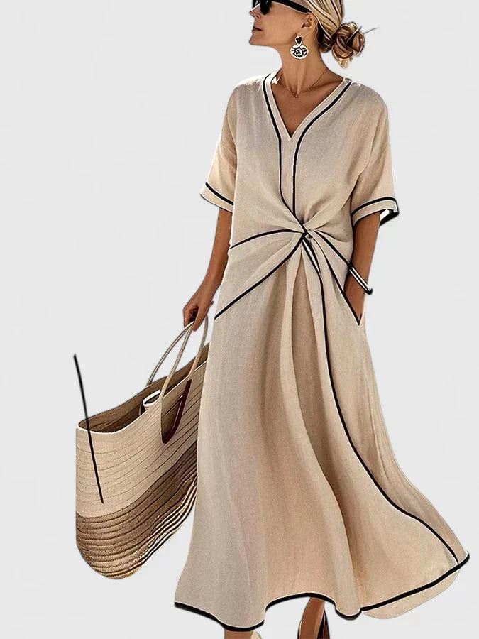 Close-up of women's V-neck maxi dress showing contrast trim detail & stylish twist front design.