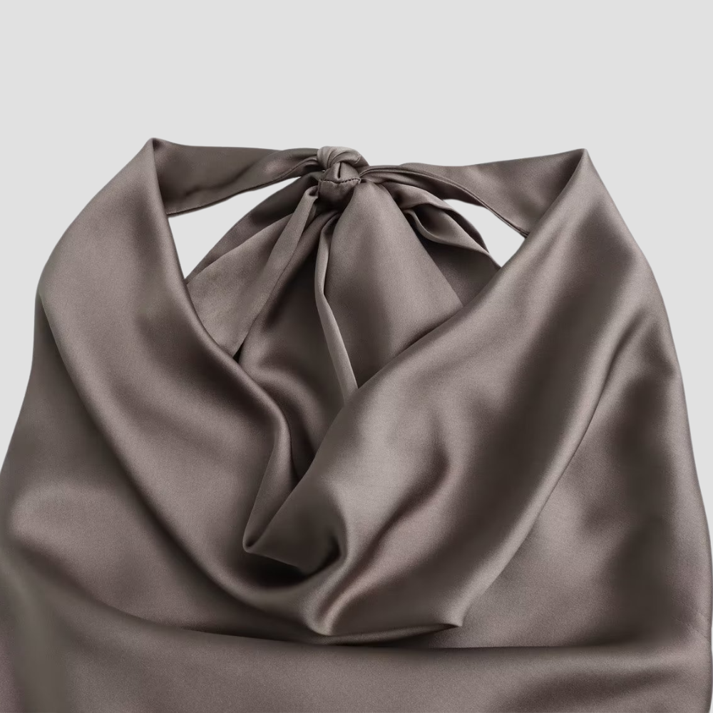 Close-up of the delicate cowl neck drape and satin fabric on a women's halter tank top.