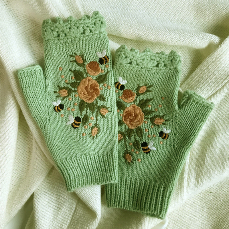 Delicate floral embroidery on women's black acrylic winter gloves, adding a touch of sophistication.