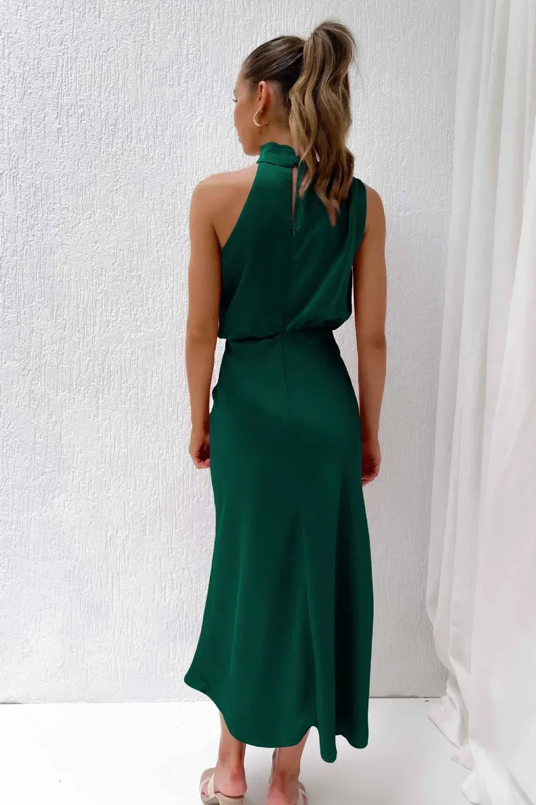 Detail of the stylish open back design on a women's formal halter evening gown, long & chic.