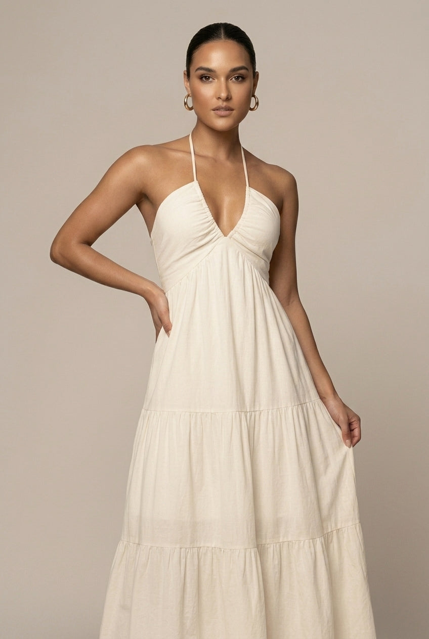 Beautiful women's halter neck sundress with a tiered ruffle maxi skirt, open back, and tie waist for beach or resort.