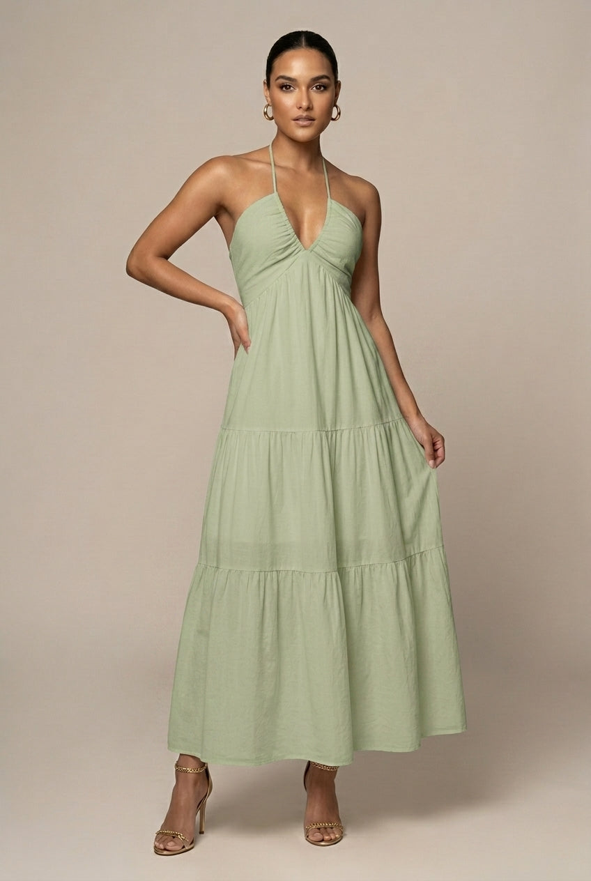 Flowy women's party maxi dress, halter neck, tiered ruffle skirt, and open back, perfect for special occasions.