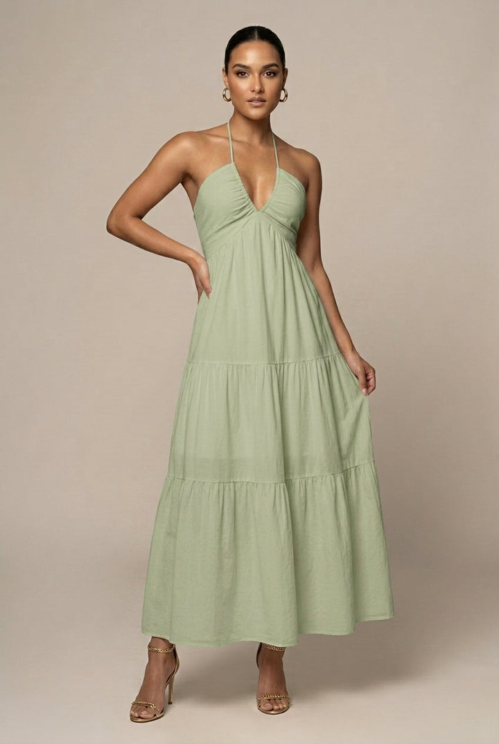 Flowy women's party maxi dress, halter neck, tiered ruffle skirt, and open back, perfect for special occasions.