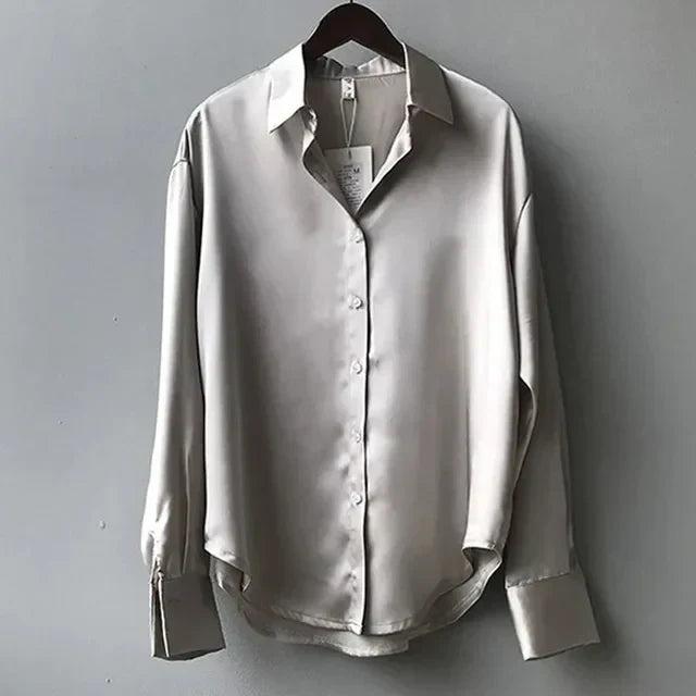 Luxurious women's long sleeve button-down satin blouse in a rich color, offering an elegant and refined look.