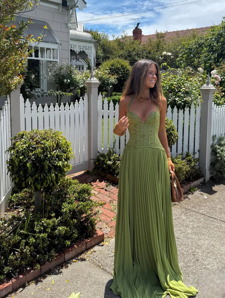 Women's formal green maxi gown. Elegant pleated evening dress with corset detailing for wedding guests.