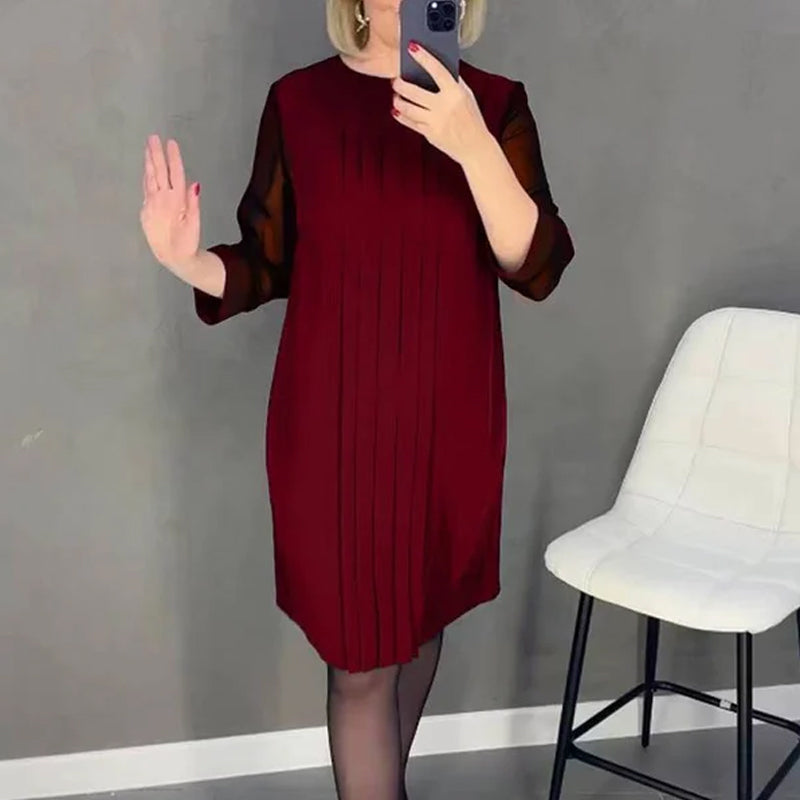 Close-up of the round neck and pleated fabric on a women's midi dress, stylish and modern