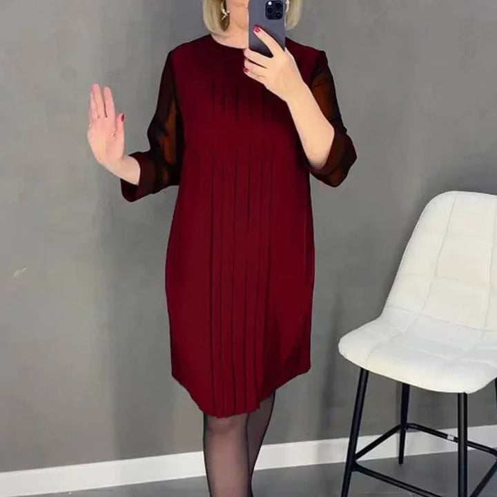 Close-up of the round neck and pleated fabric on a women's midi dress, stylish and modern