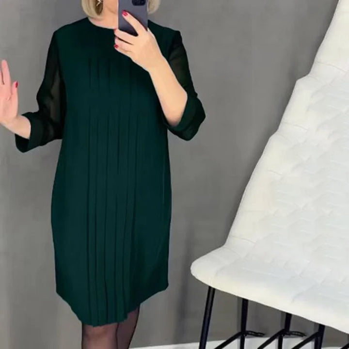 Woman wearing a mid-sleeve pleated midi dress, showcasing its elegant and casual fit