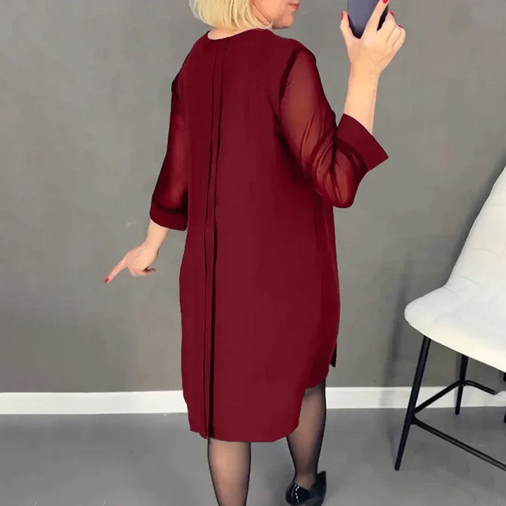 Back view of a women's round neck midi dress with pleats, highlighting its flowing design