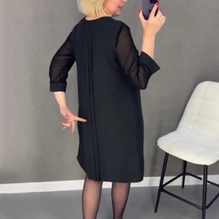 Detail of the mid-sleeve on a women's elegant pleated midi dress, suitable for all seasons