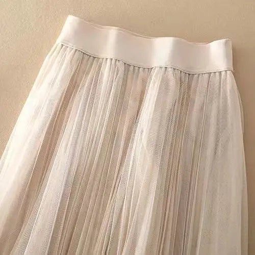 Detailed view of women's elegant pleated A-line midi skirt. Flowy high-waist design, versatile for summer.
