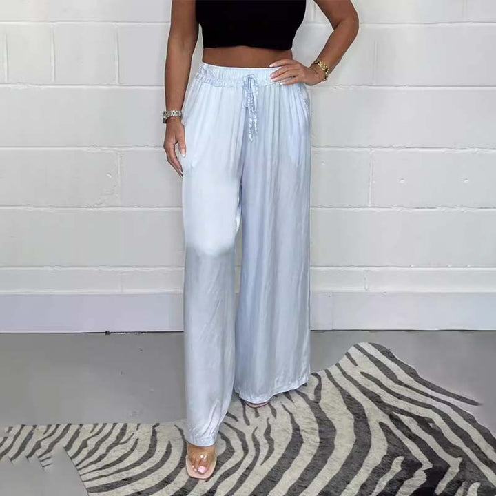 Close-up of the lace-up detail on women's satin wide-leg trousers, showcasing fashion