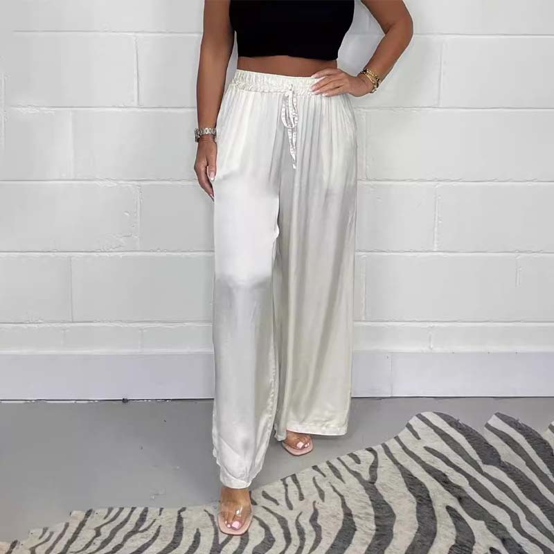 Full-length view of women's pleated satin wide-leg pants, offering comfort and style