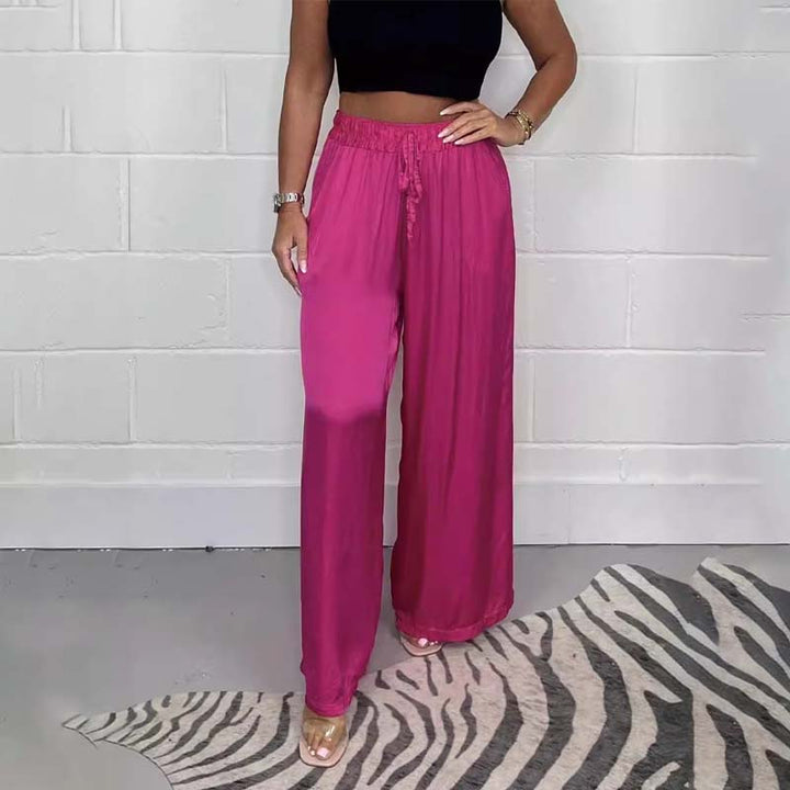 Comfortable women's wide-leg trousers in satin fabric with elastic waist, perfect for autumn