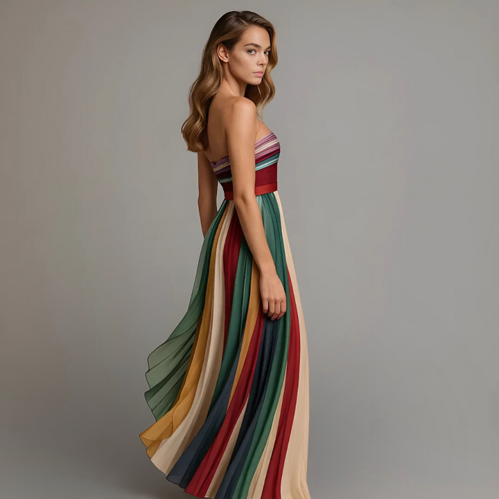 Flowing women's strapless maxi dress, elegantly pleated with colorful vertical stripes for a stylish evening look.